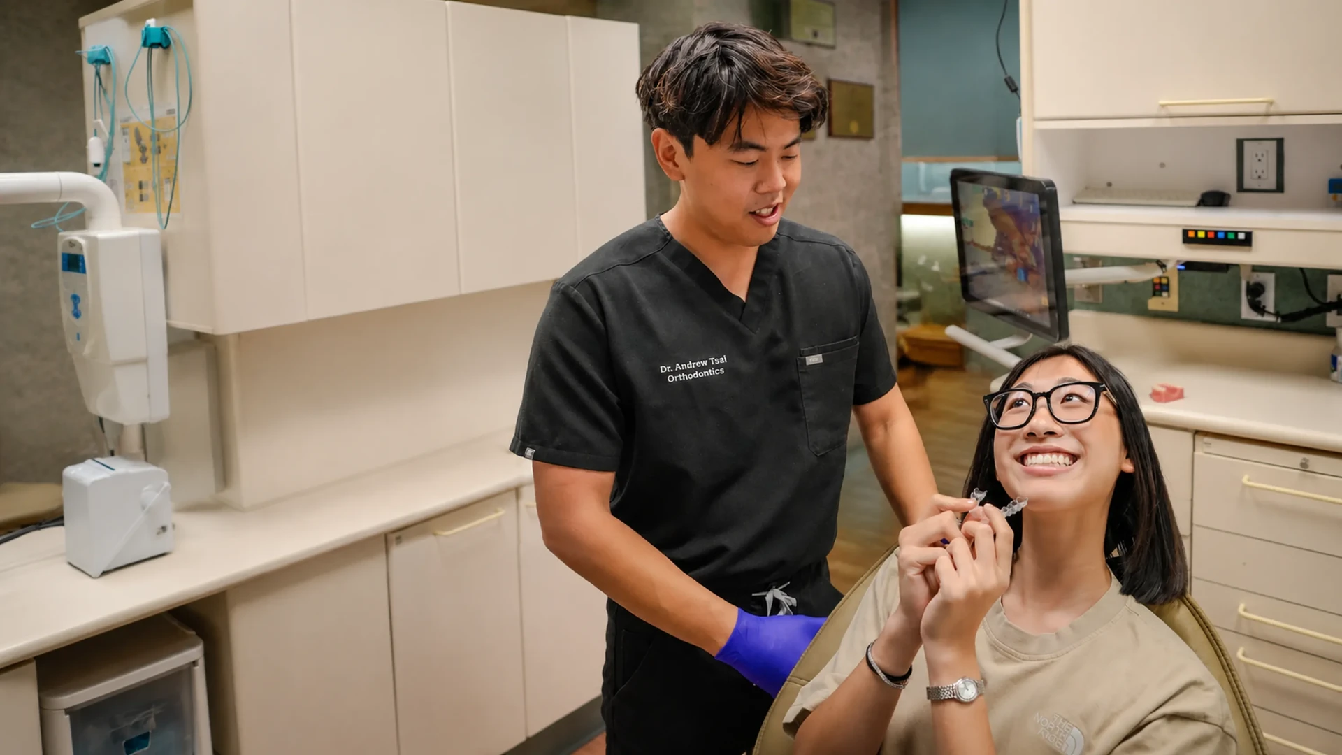 Dr. Andrew Tsai reviewing a clear aligner with a teen patient